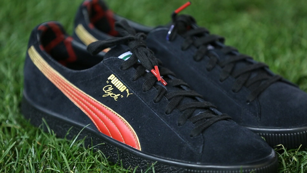 A pair of black, red and yellow Puma's designed by Indigenous artist Robert Michael Young