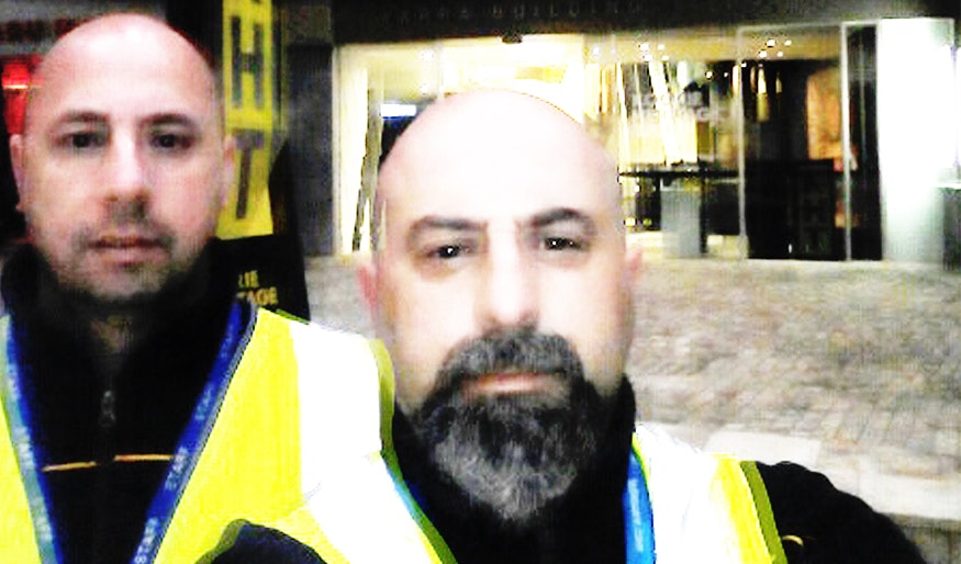 Two Fed Square security guards taking a blurry selfie in high vis vests that is a little bit spooky