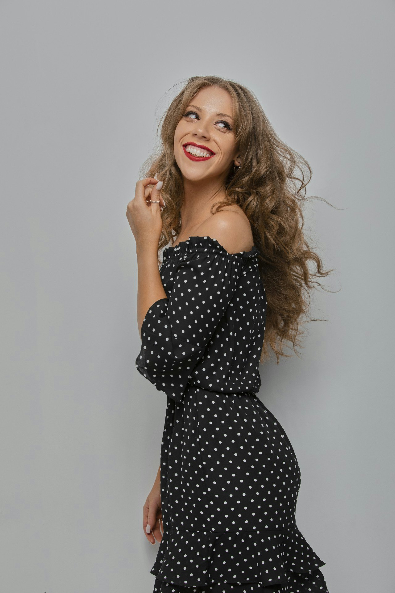 DJ Brittany Leo posing in a black dress with white polka dots