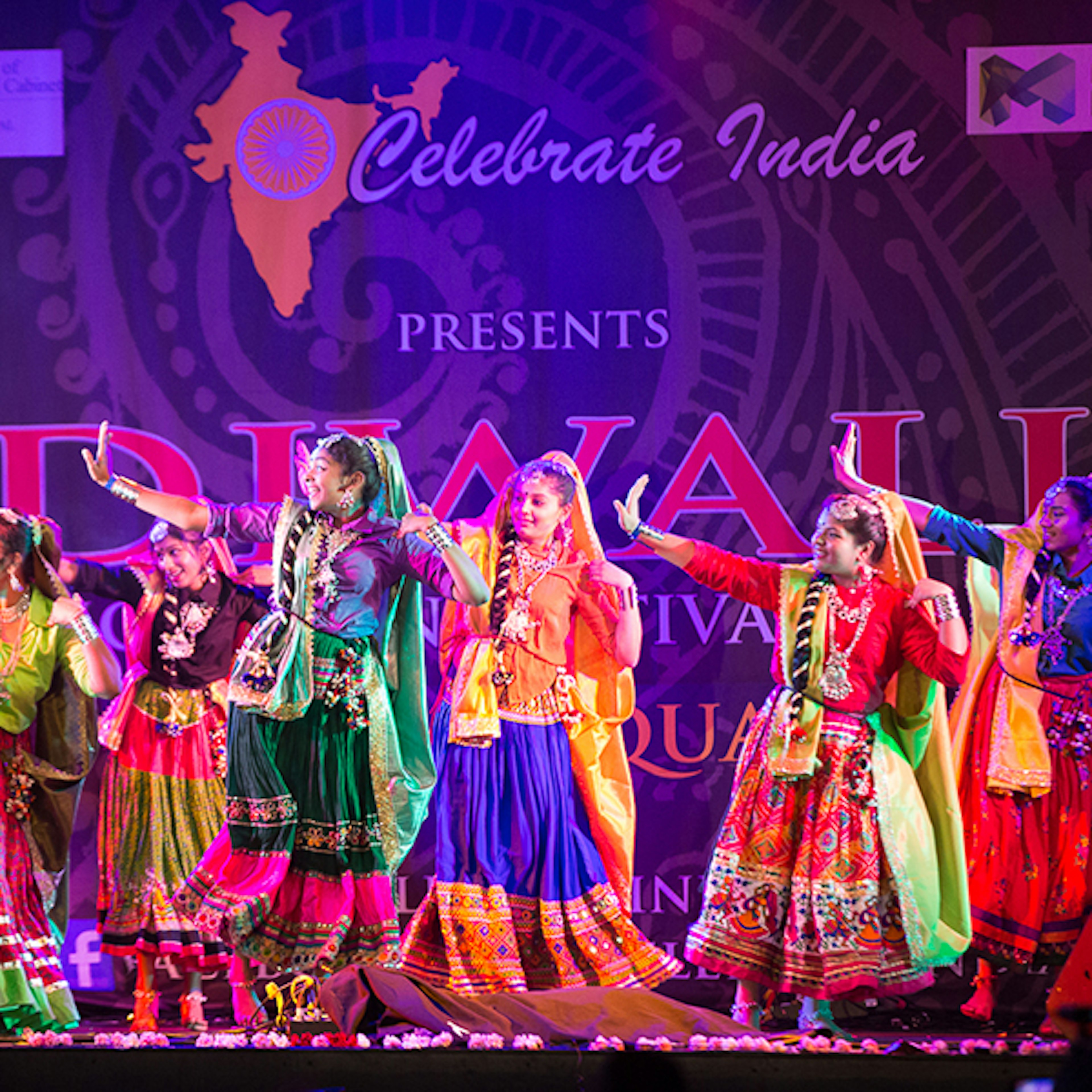 Many Indian women dancing on stage at Fed Square in bright colourful saris for the Diwali festival