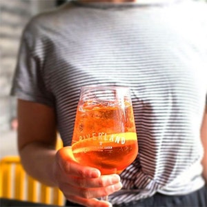 A person holding an aperol spritz at Riverland Bar