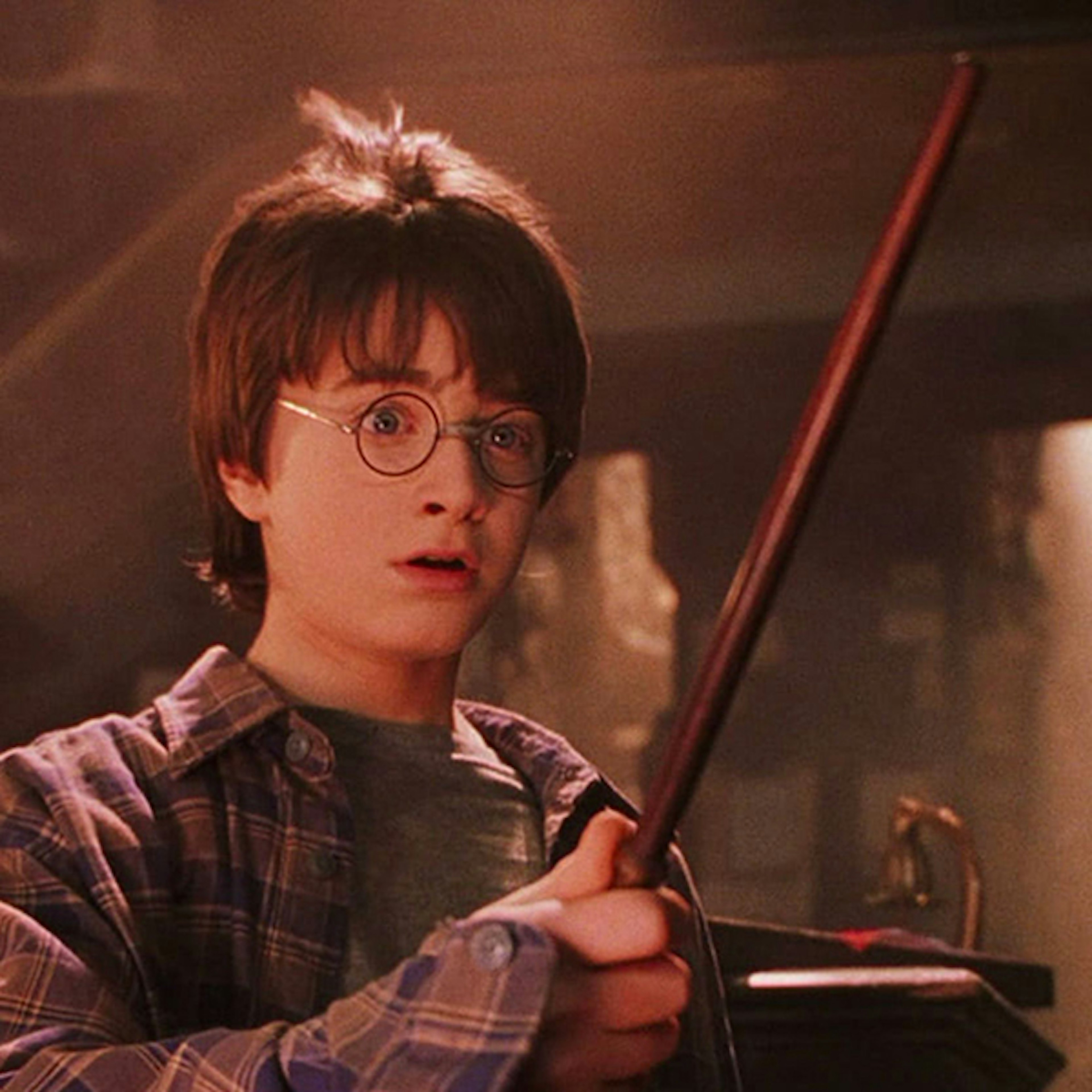 Harry Potter holding his wand in Ollivander's shop in the Philosopher's Stone