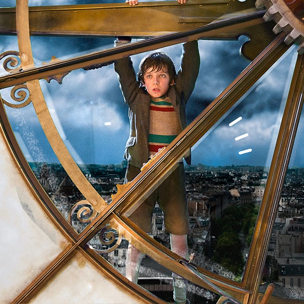 A photo of Hugo holding to the outside of the clock featured in the film