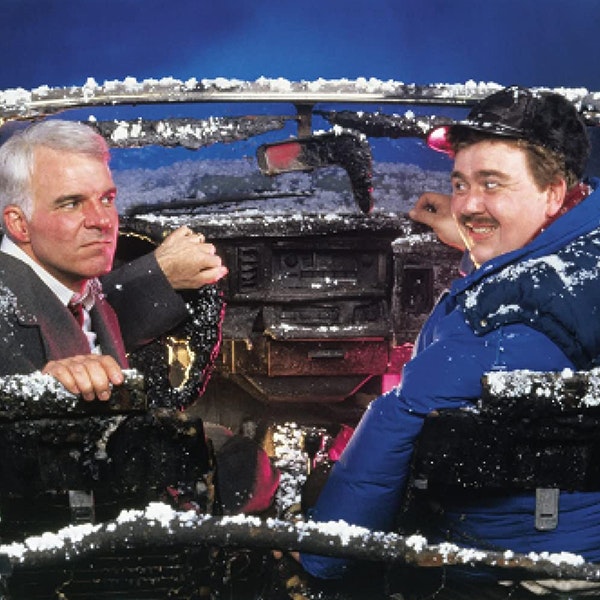 A photo of Steve Martin and John Candy giving each other a sideways glance in a convertible covered in snow