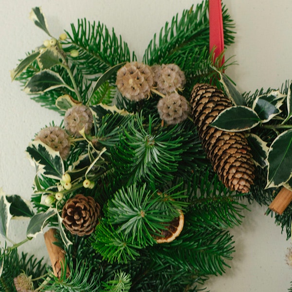 A green christmas wreath with pine and pine cones