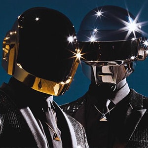 The two members of Daft Punk posing for a photo wearing their gold and silver helmets