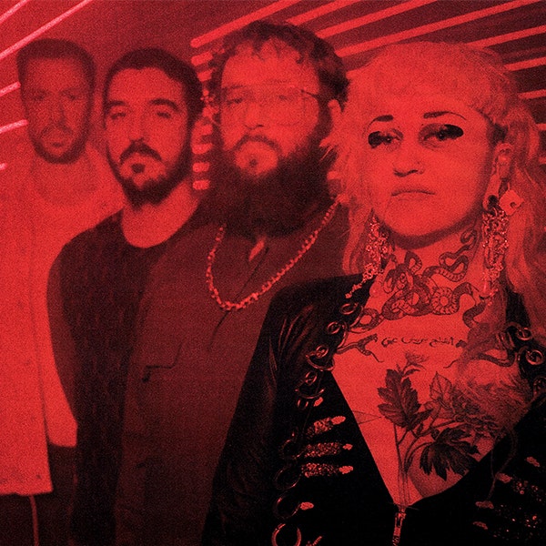 The members Haitus Kaiyote looking at the camera lined up next to each other under red light