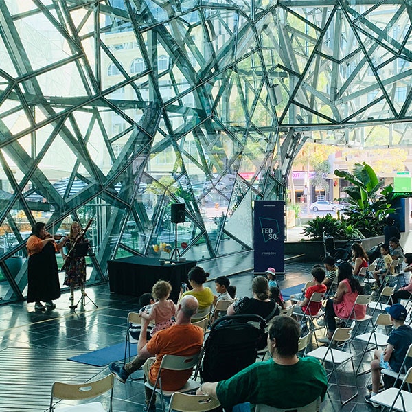 A violinist and oboist performing in the Atrium at Fed Square