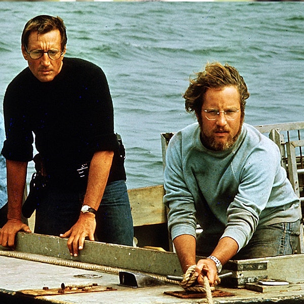 Roy Scheider and Richard Dreyfus are leaning over the edge of a boat looking for Jaws