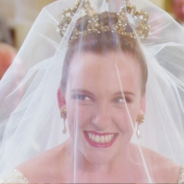 Toni Collette in Muriel's Wedding is wearing her veil and smiling up at the groom who is off camera
