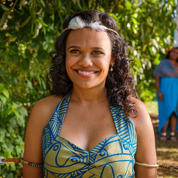 Miranda Tapsell is smiling towards the camera in her blue and green wedding dress in Top End Wedding