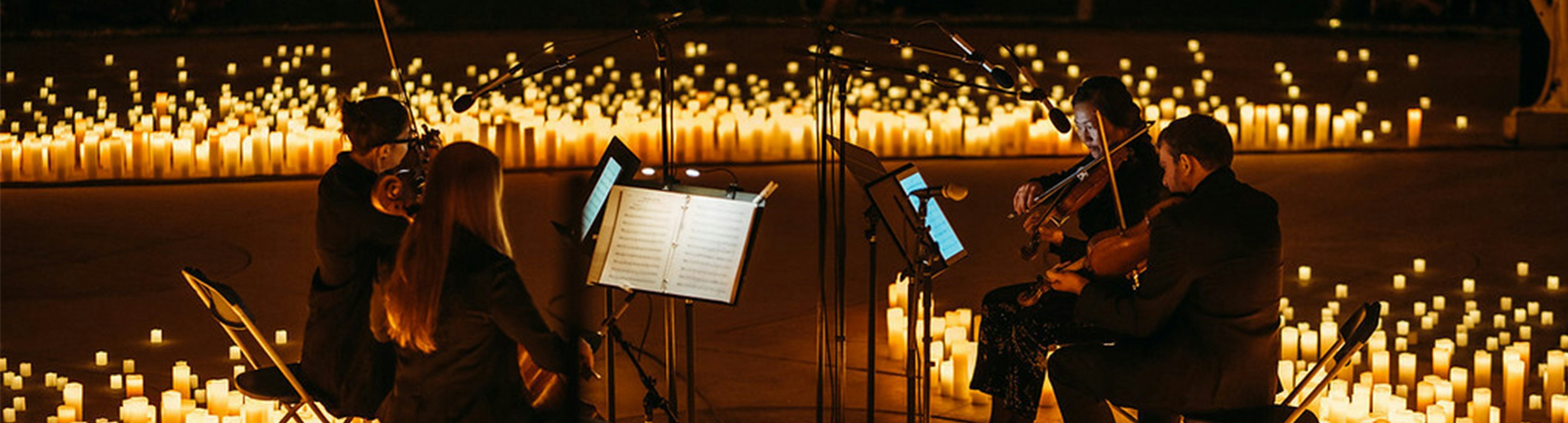 String quarter performing surrounded by candles for the Candlelight Concert Series