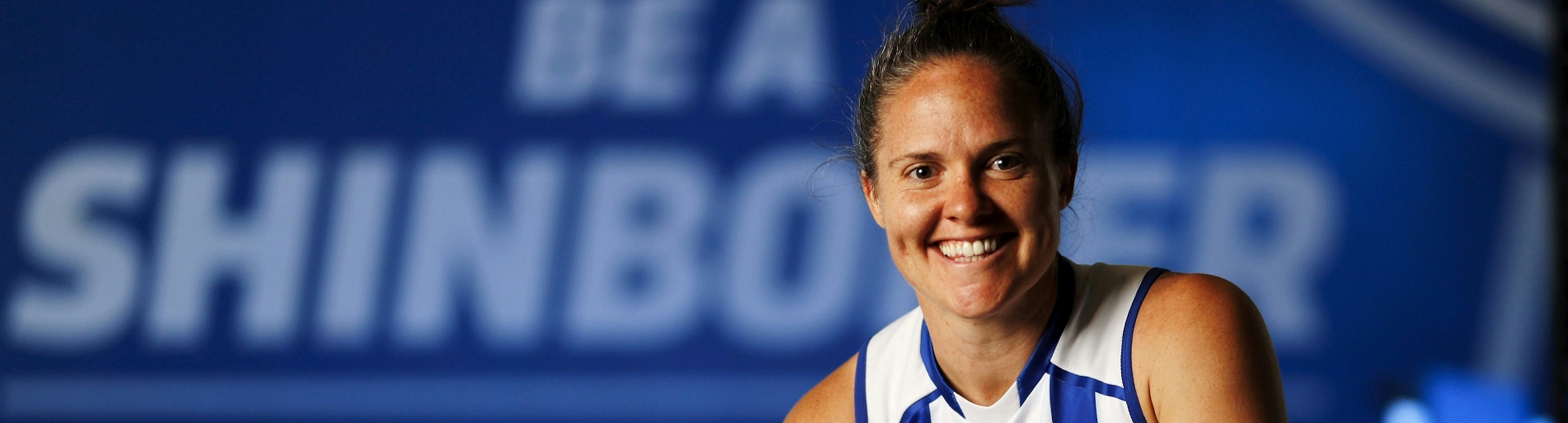 An AFLW player for the North Melbourne Kangaroos smiling at the camera