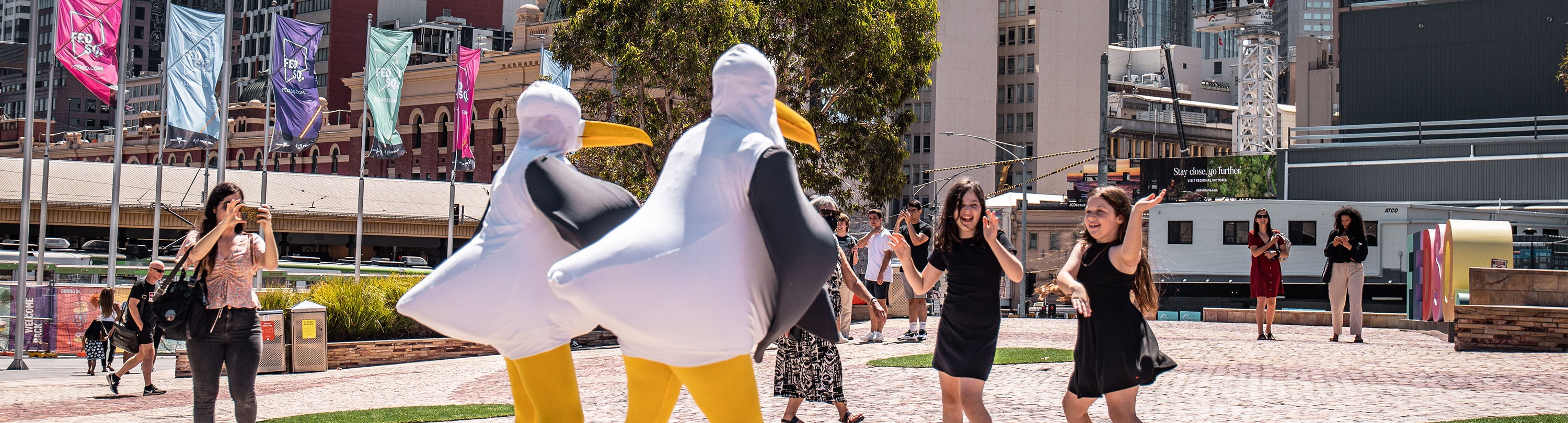 Kids dancing with Fred and Fifi the seagulls at Fed Square