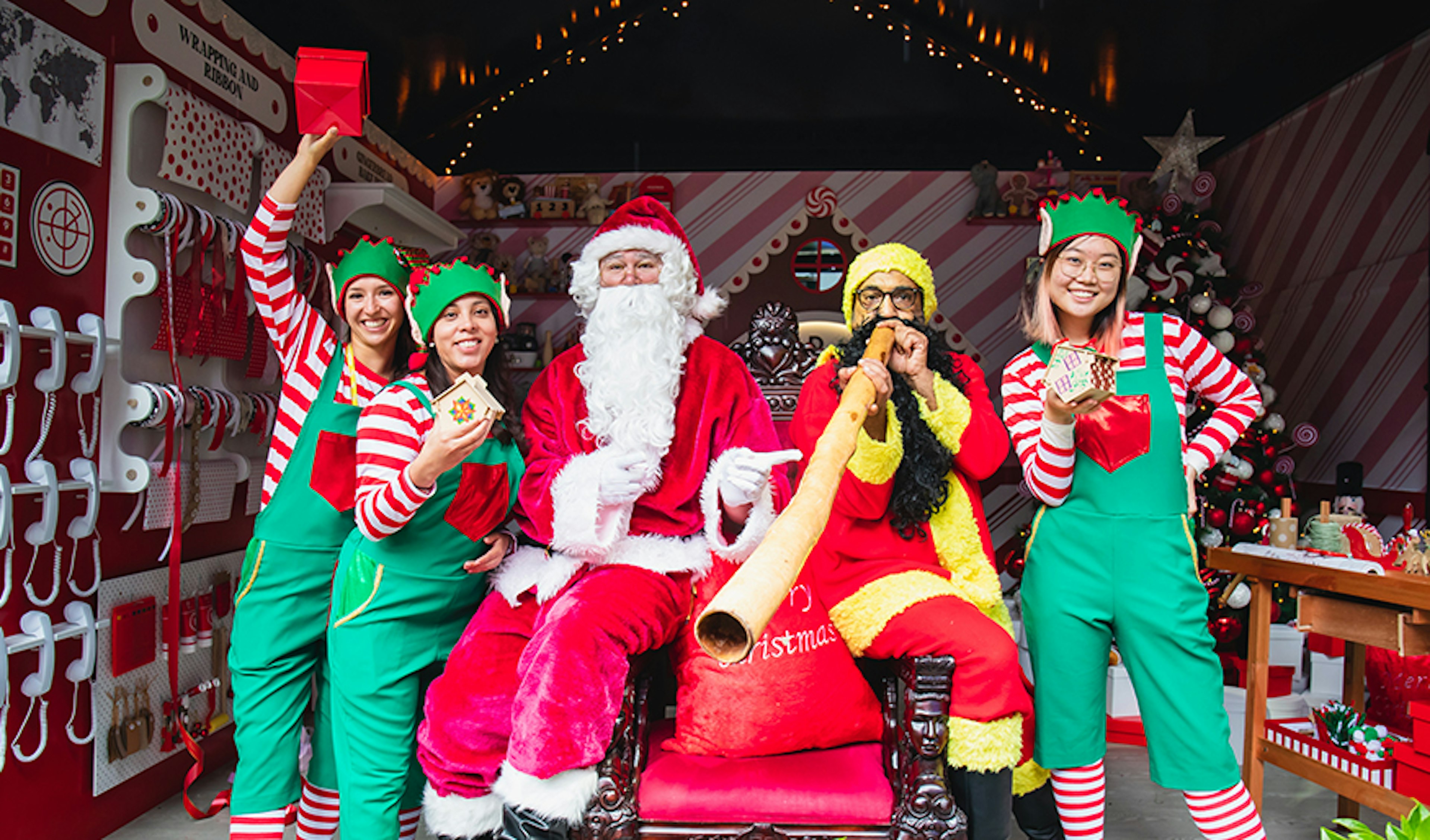 Koorie Klaus and Santa Claus pose with the elves at Santa's Workshop