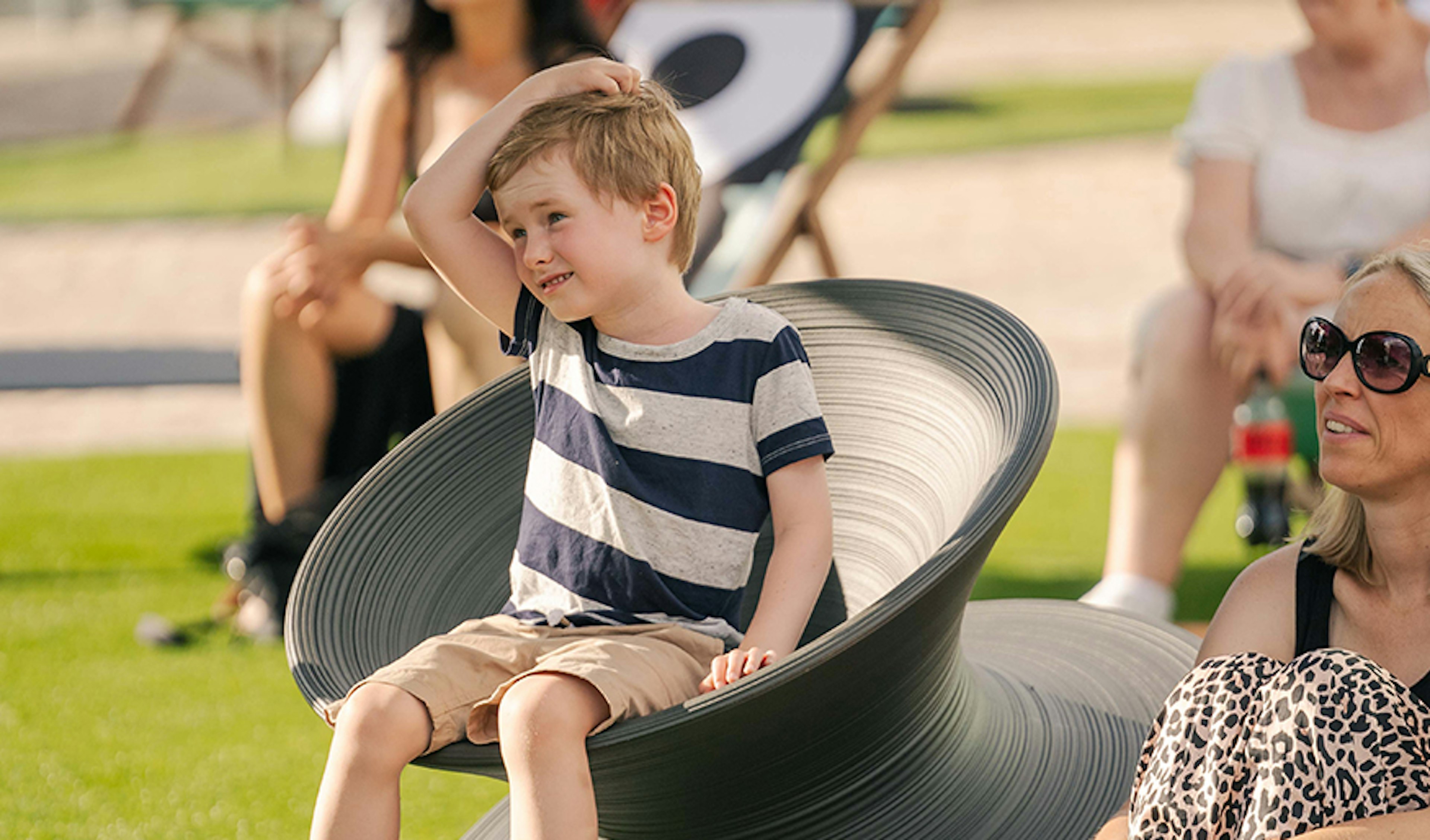 Kid on a spun chair, which looks like a larger thimble, at Fed Square