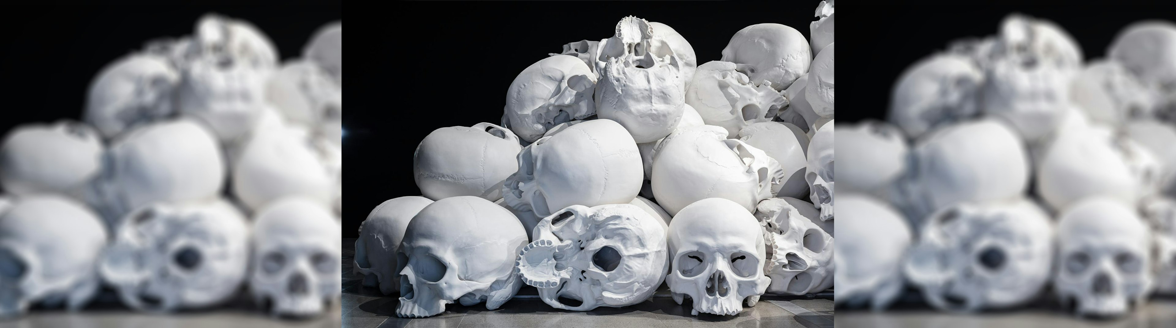 A sculpture of large human skulls piled up on one another