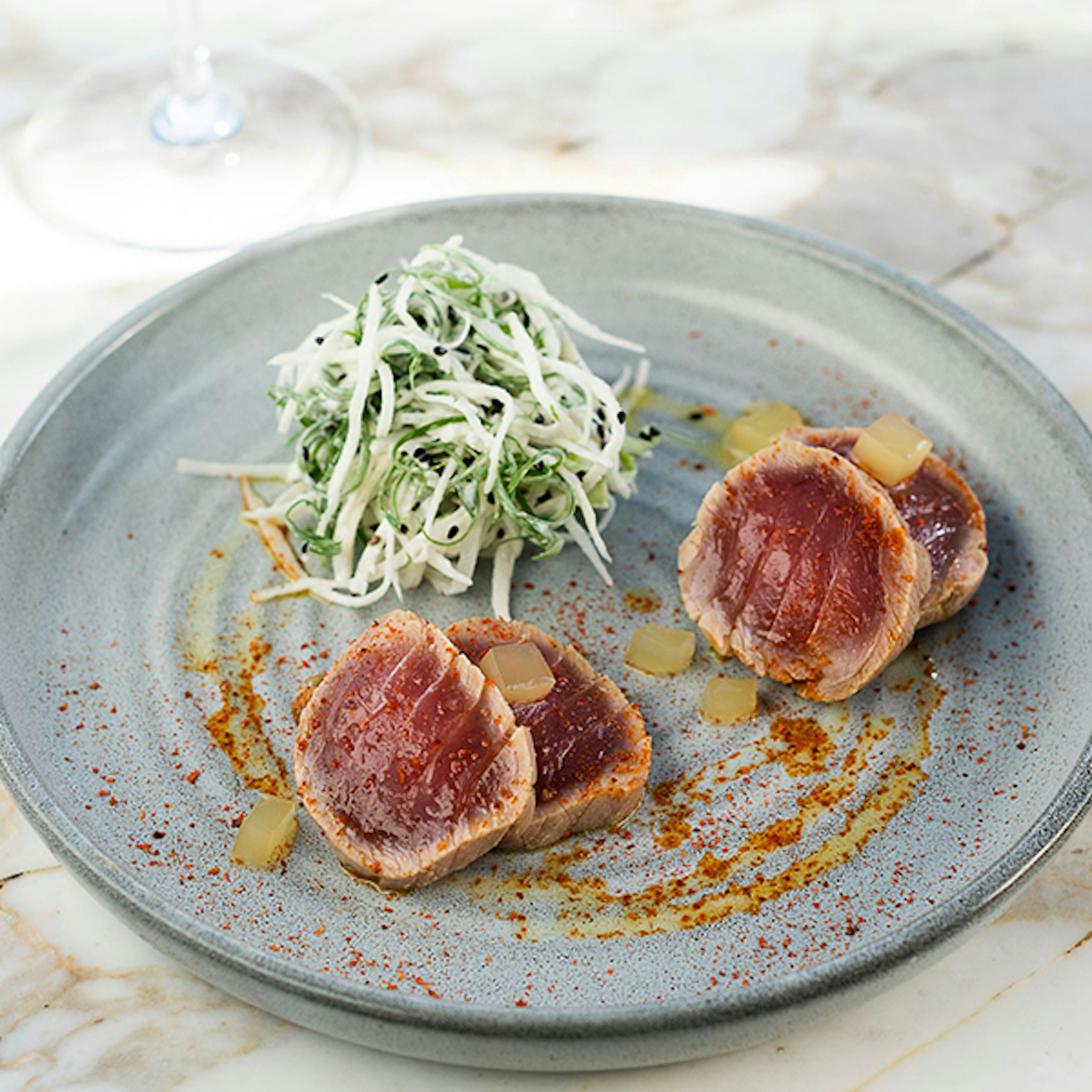 Four lightly seared slices on tuna on a grey plate