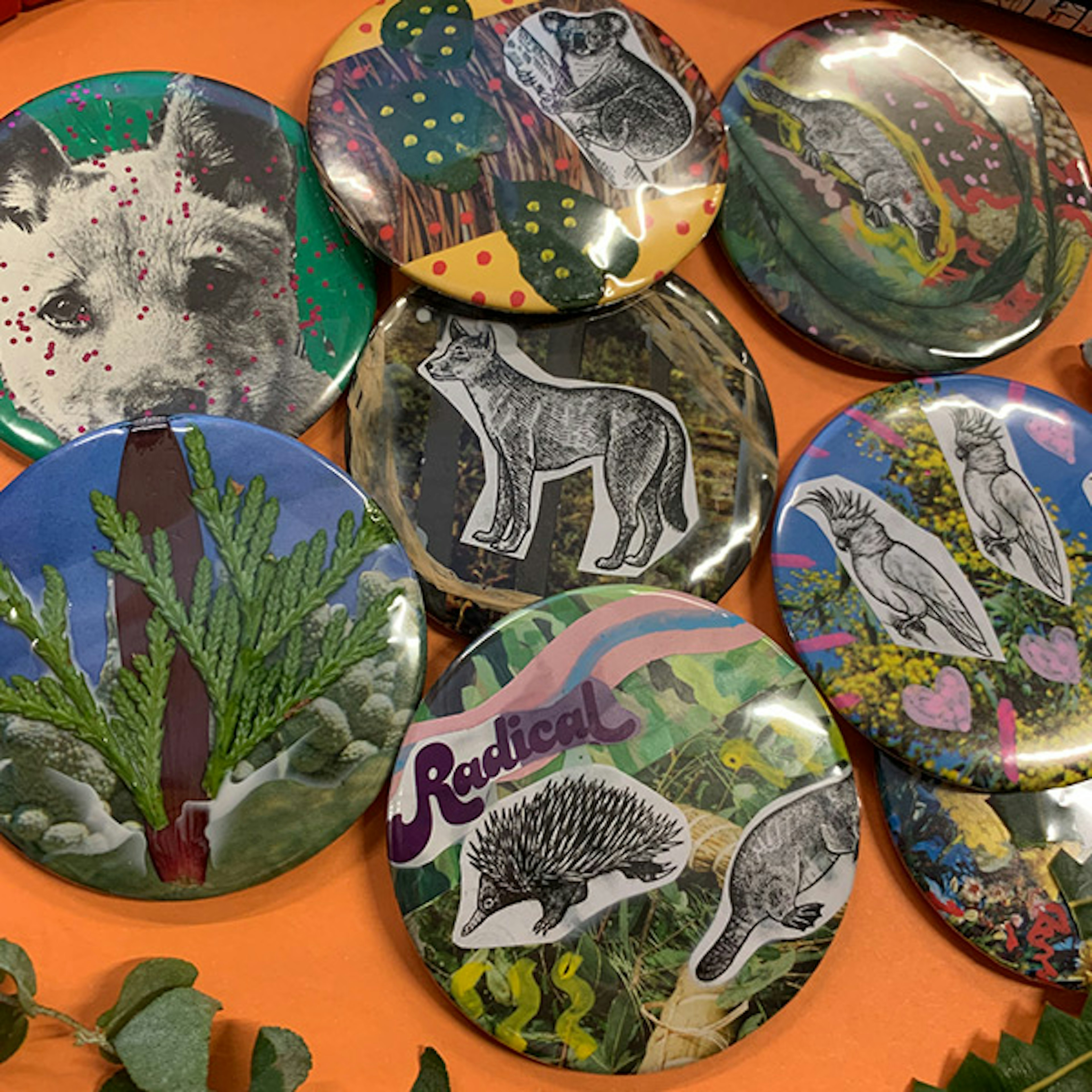 A collection of hand painted badges sitting on an orange table