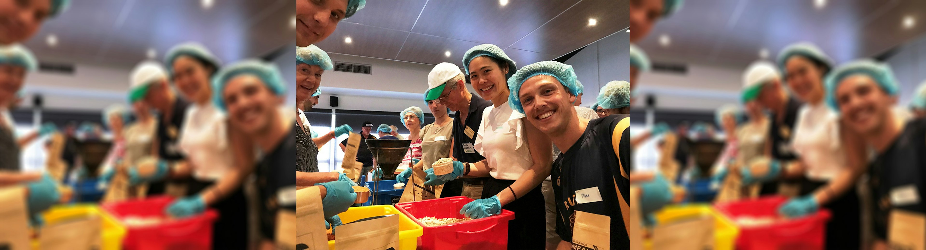 A group of volunteers packing food for Rotary International