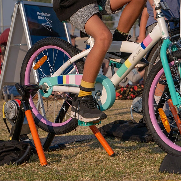 The back wheel of a child's bicycle is connected to a power unit