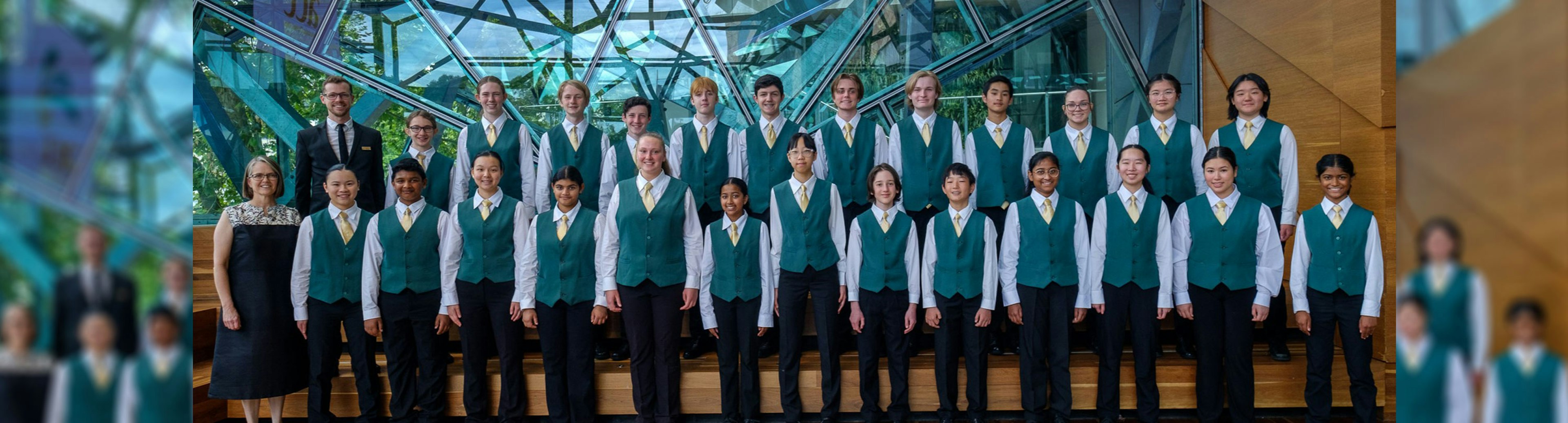 A children's choir lined up in two rows posing for a photo in The Edge at Fed Square