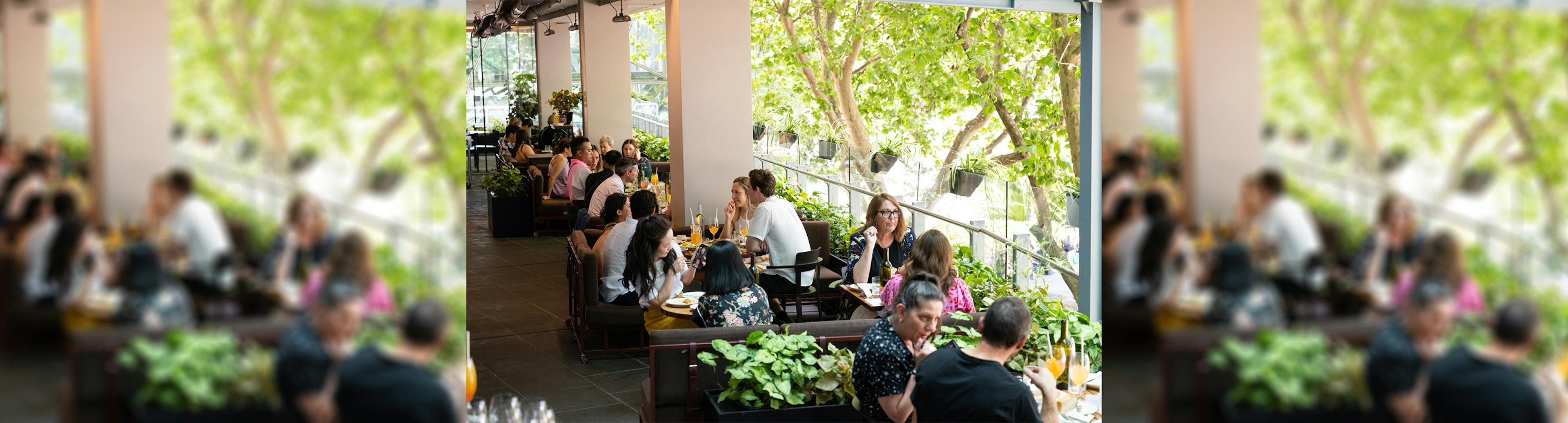 People sitting on the terrace of Victoria by Farmer's Daughters enjoying cocktails