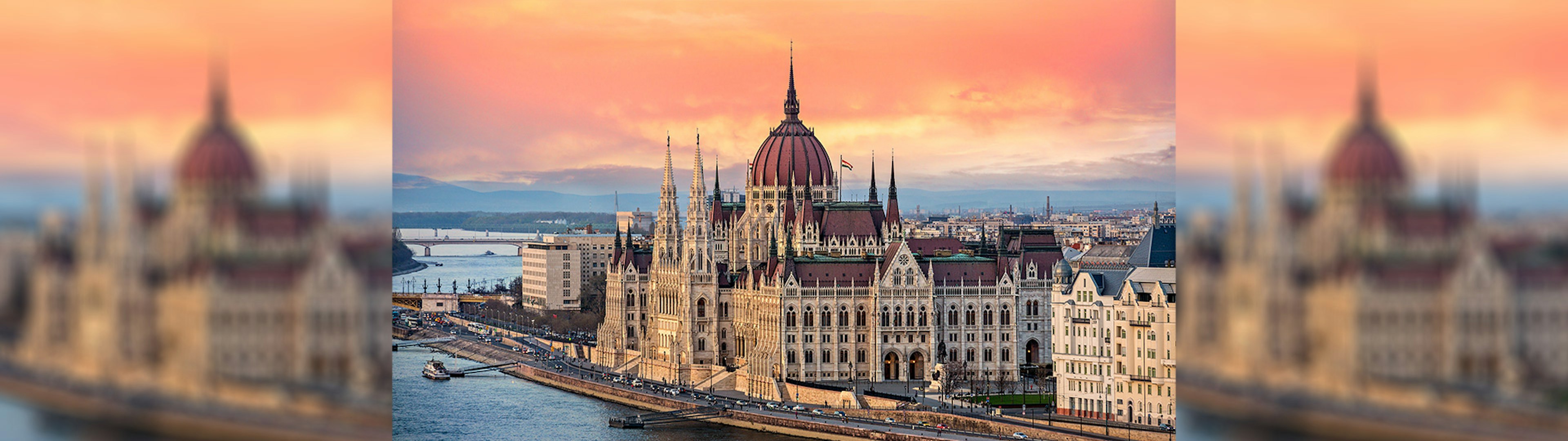 A photo of the parliament building in Budapest at sunset overlooking the Danube