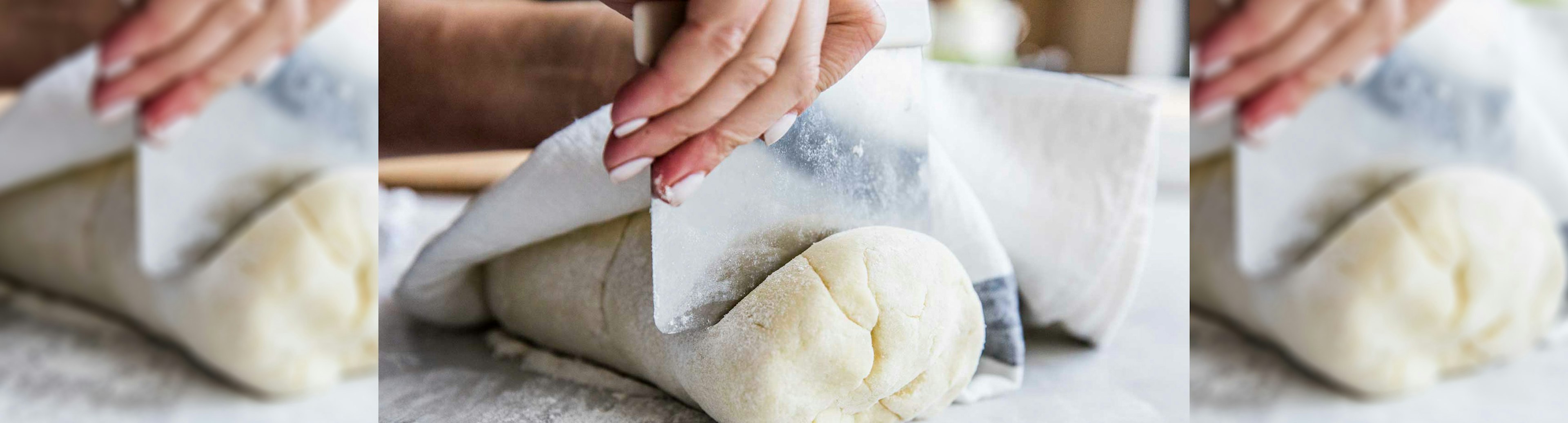 A close up of hands cutting gnocchi dough