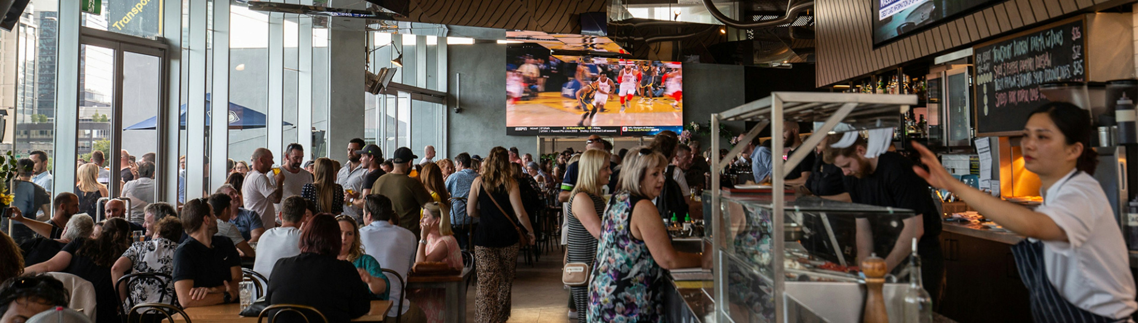 A congregation of people sitting and standing in the main bar at Transport Public Bar