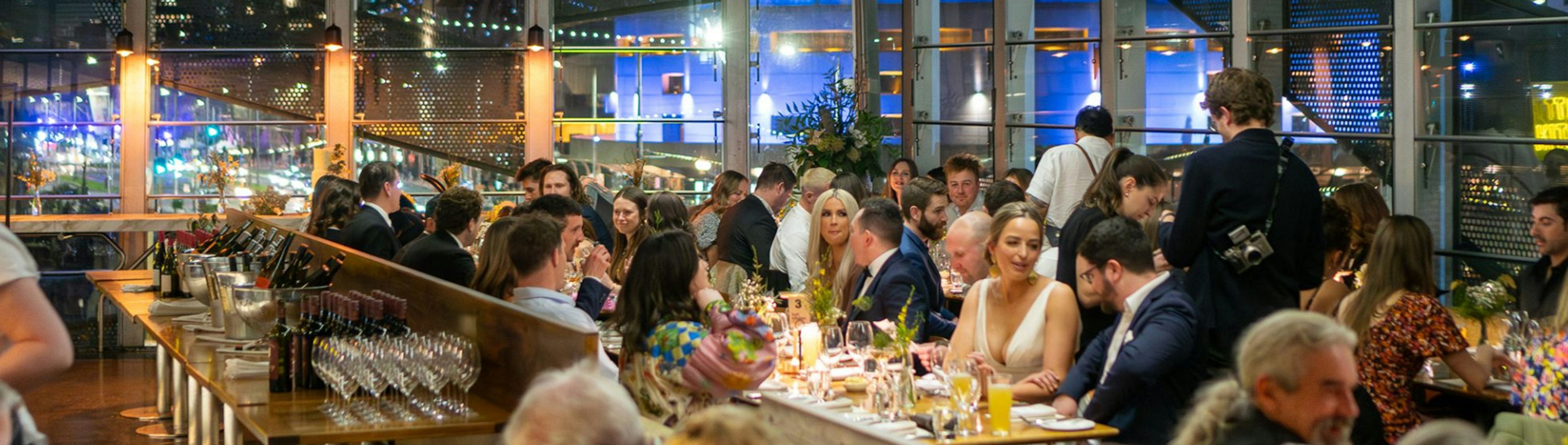 Many people sitting at tables during the reception of a wedding in Taxi Kitchen's dining space