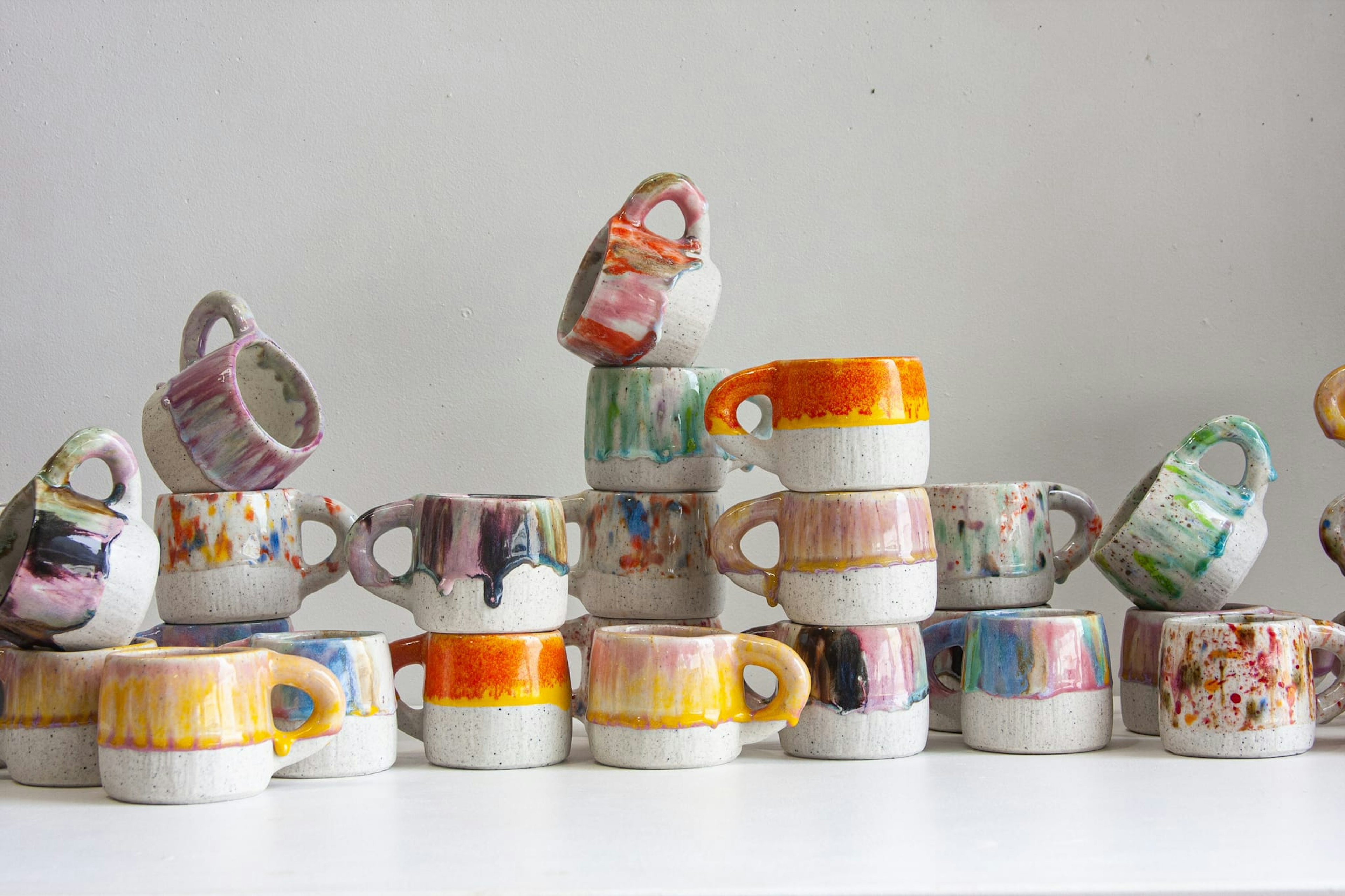 A stack of ceramic cups, with different colours.