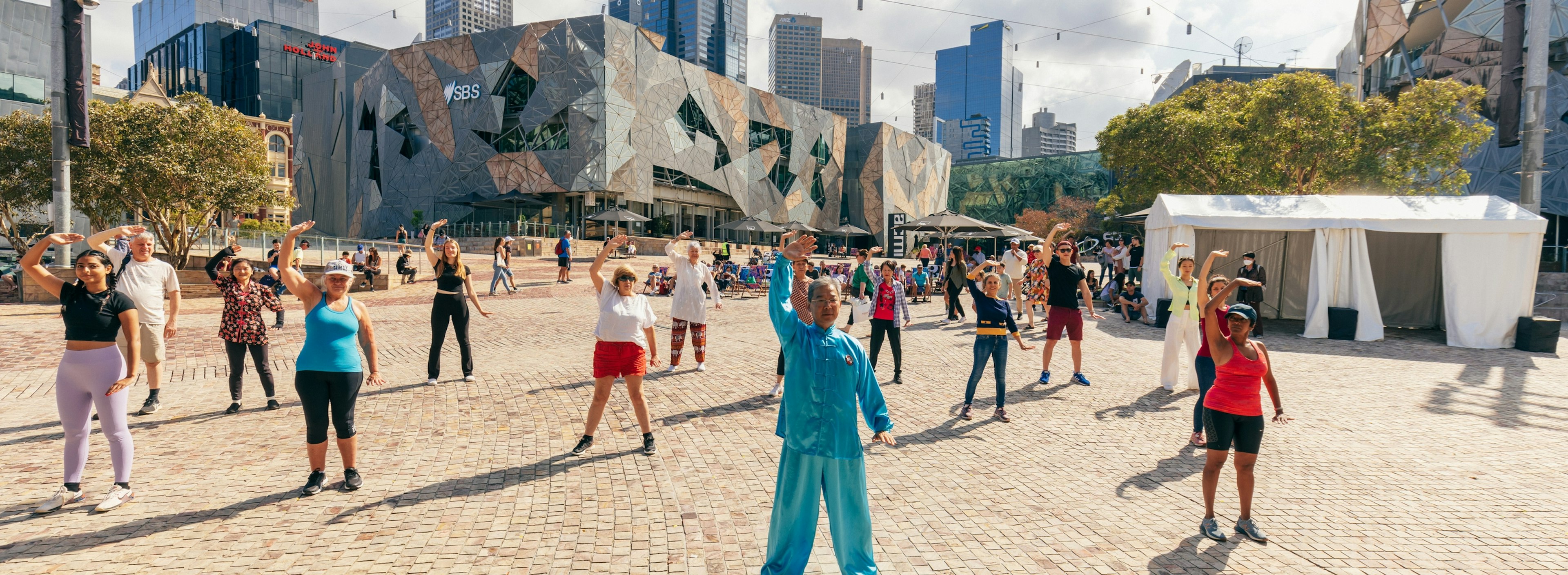 Many people enjoy Tai Chi at Fed Square, led by Master Song, in blue silks.