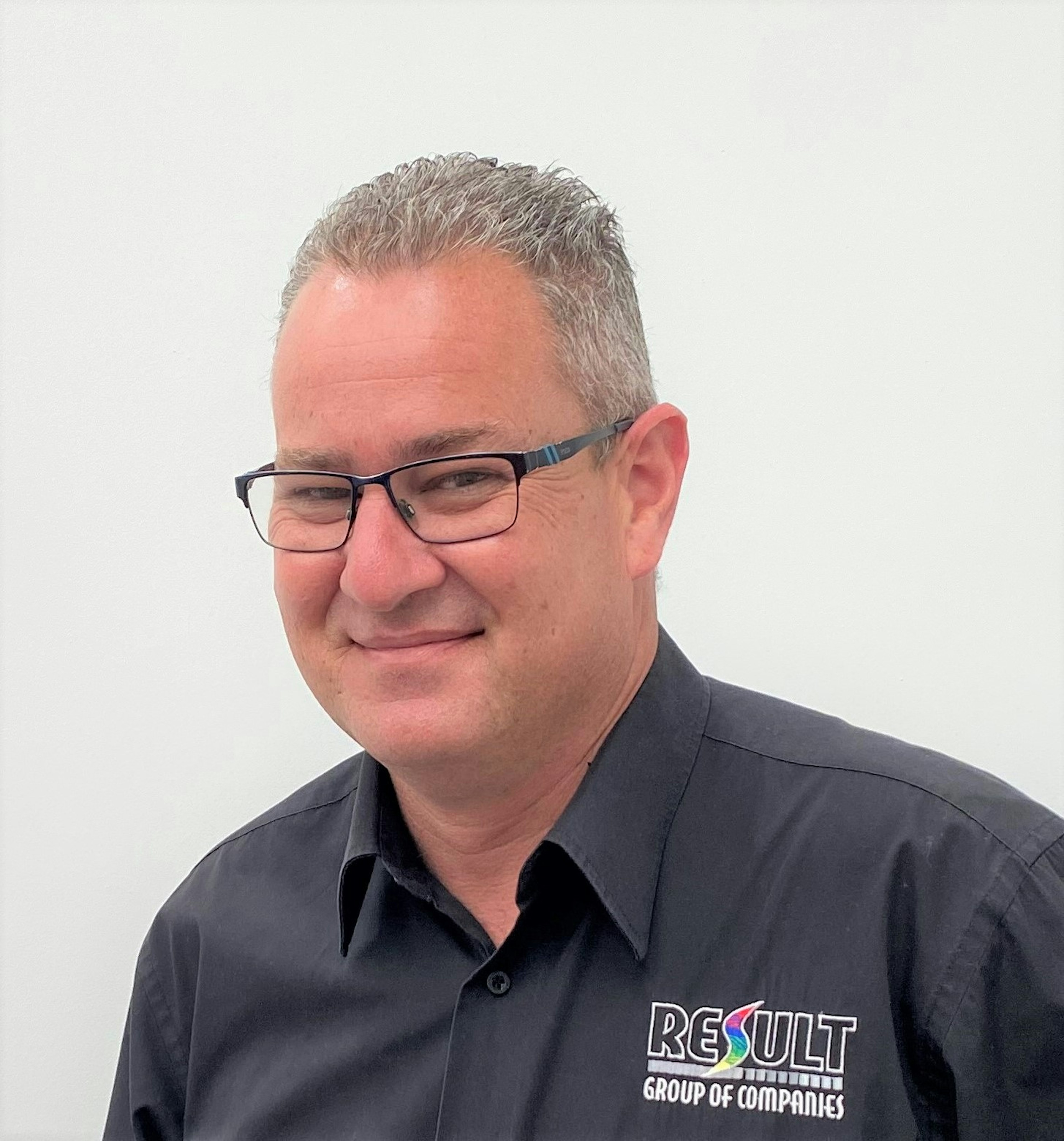 Profile portrait of a man with black-rimmed glasses, Michael Dossor from Result Group